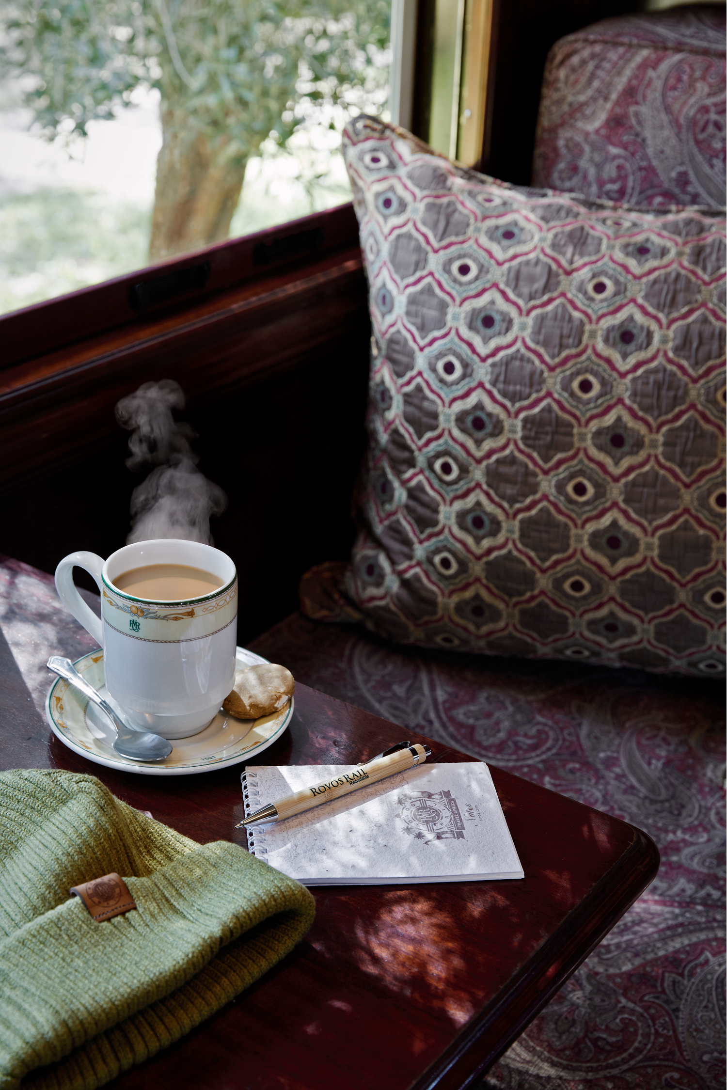 Tasse Kaffee auf einem Tisch im eleganten Rovos-Rail-Zugabteil mit Blick aus dem Fenster.