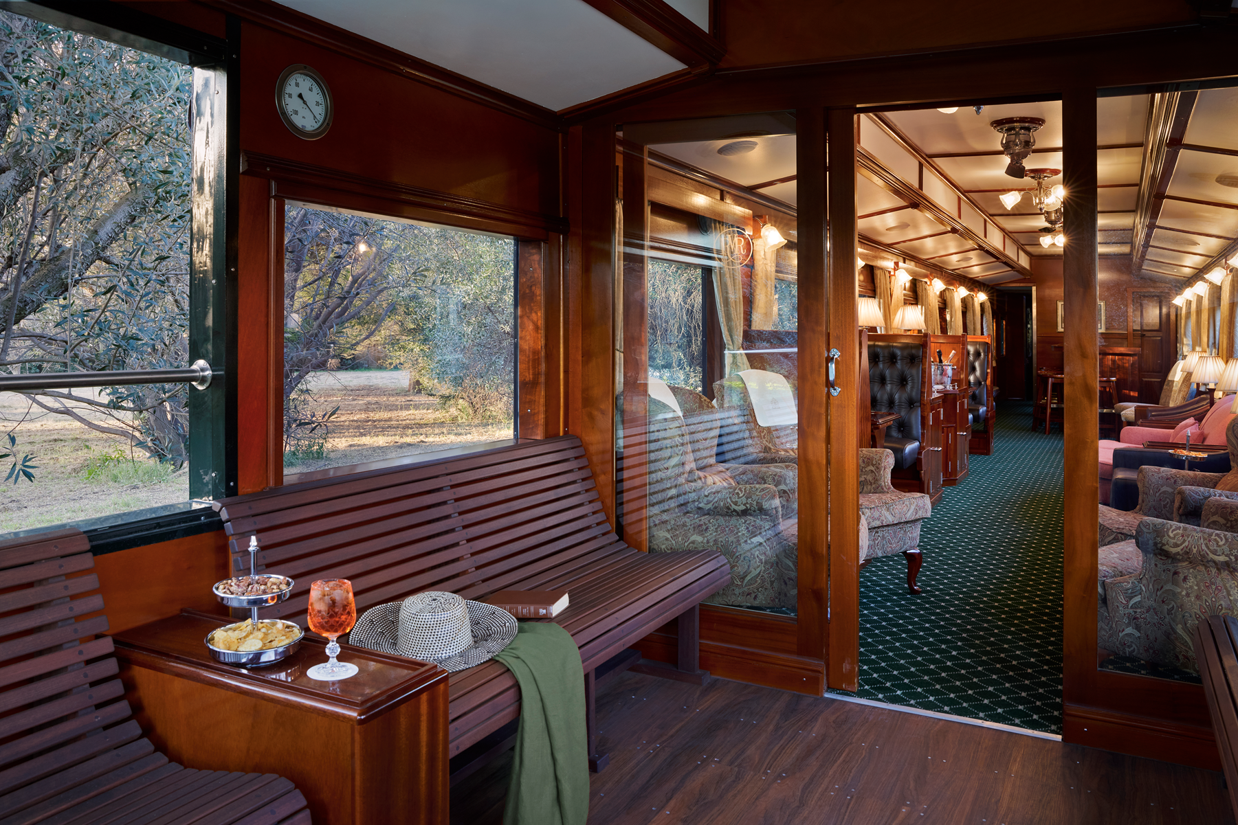 Offener Aussichtswagen des Rovos Rail mit Sitzgelegenheiten und Blick auf die vorbeiziehende afrikanische Landschaft.