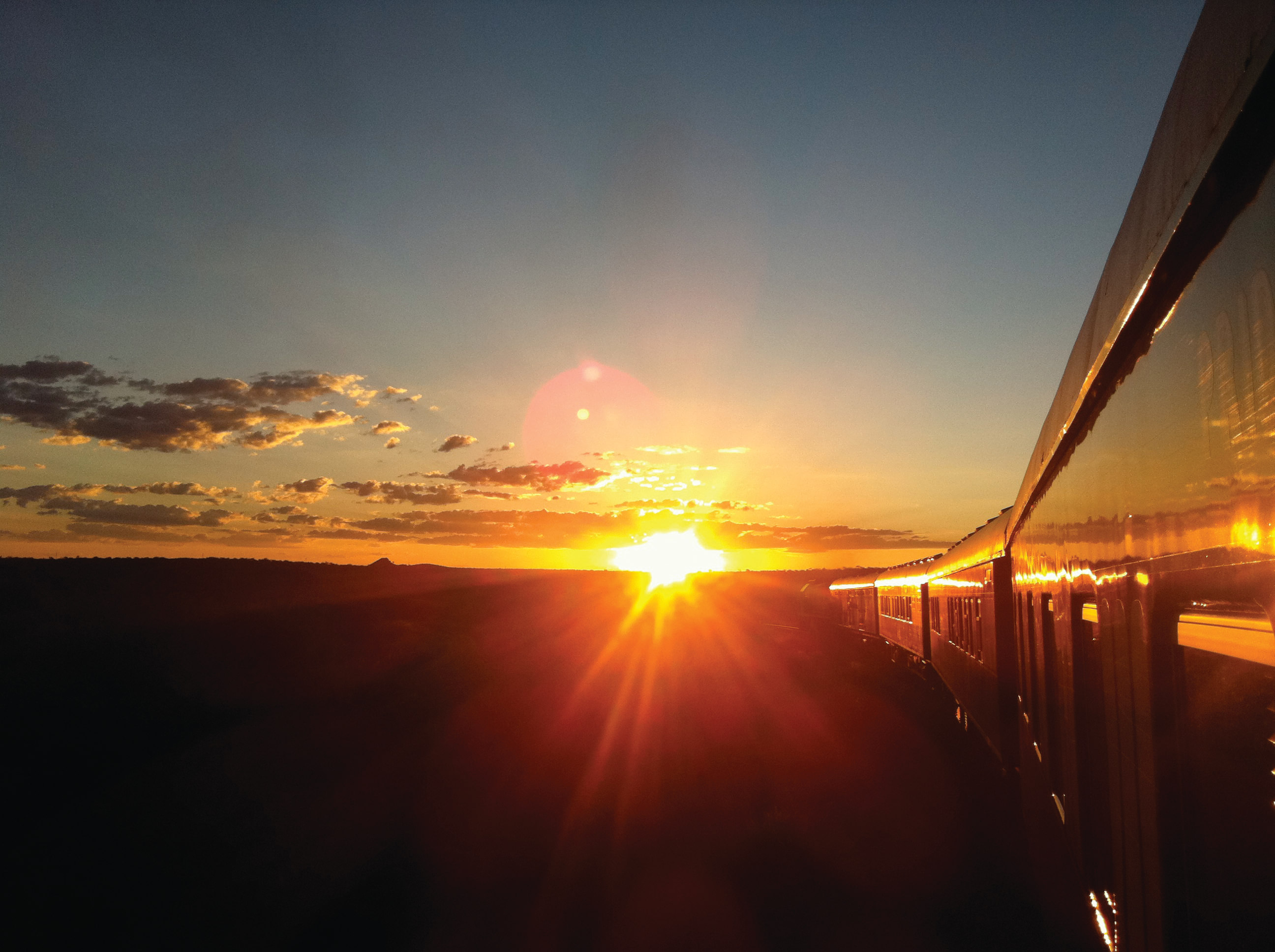  Rovos Rail Luxuszug bei Sonnenuntergang in der südafrikanischen Weite zwischen Kapstadt und Pretoria.