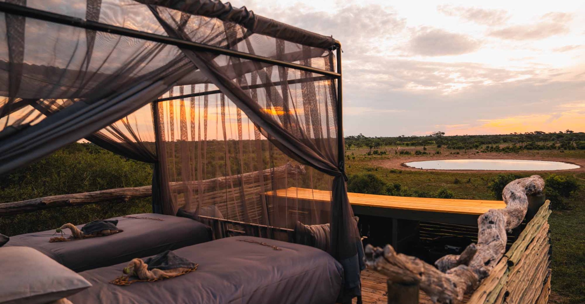 Offenes Skybed mit Moskitonetz und Blick über die Wildnis im Little Sable Camp in Botswana.