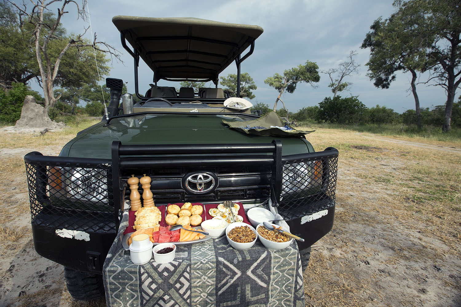 Safari-Fahrzeug mit vorbereitetem Picknick-Frühstück während einer Pirschfahrt in der Wildnis Botswanas.