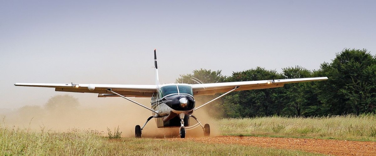 Kleinflugzeug auf einer unbefestigten Landepiste in der afrikanischen Savanne