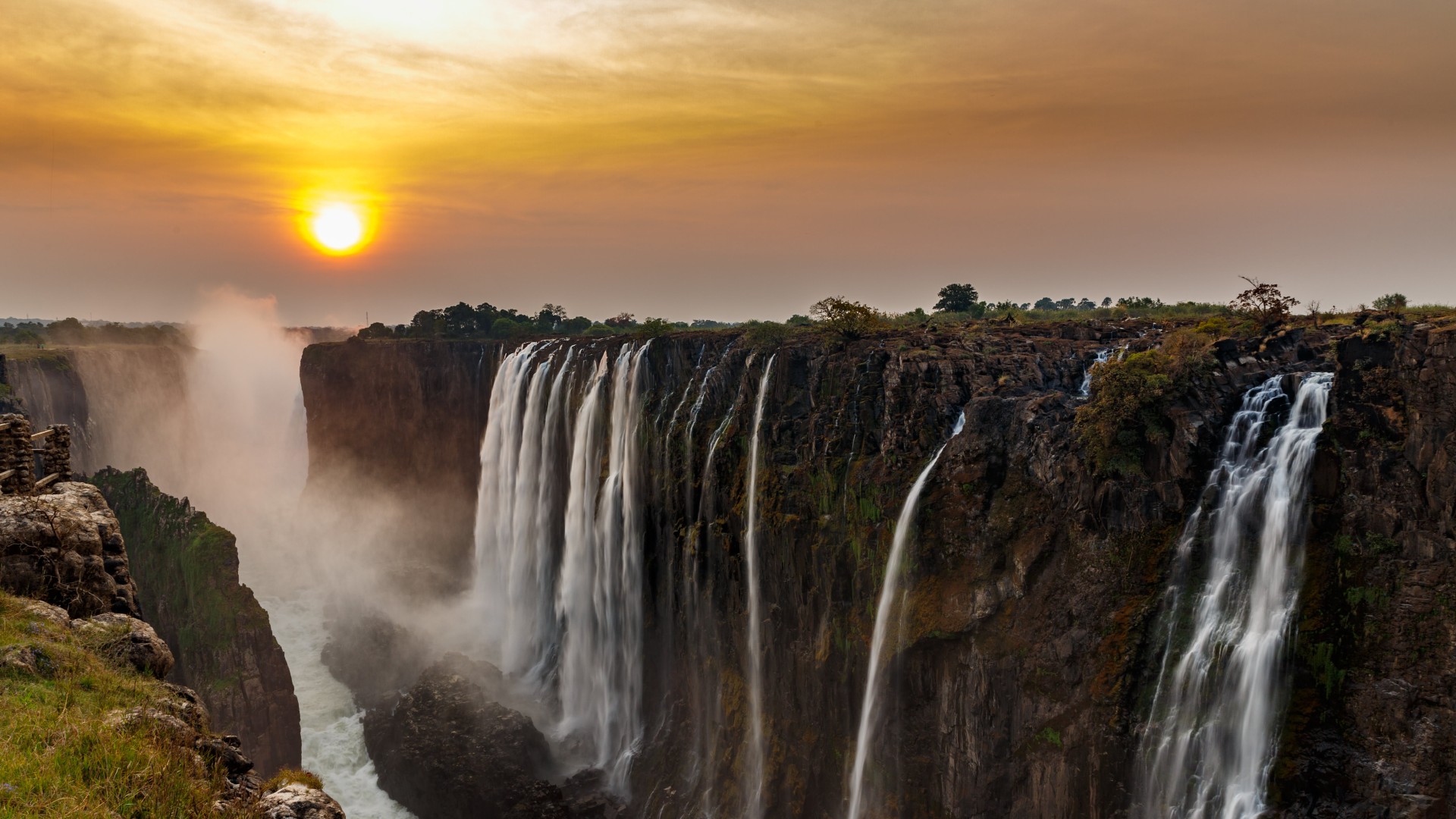 Victoria Falls bei Sonnenuntergang in Zimbabwe, wo der Sambesi spektakulär in die Schlucht stürzt.